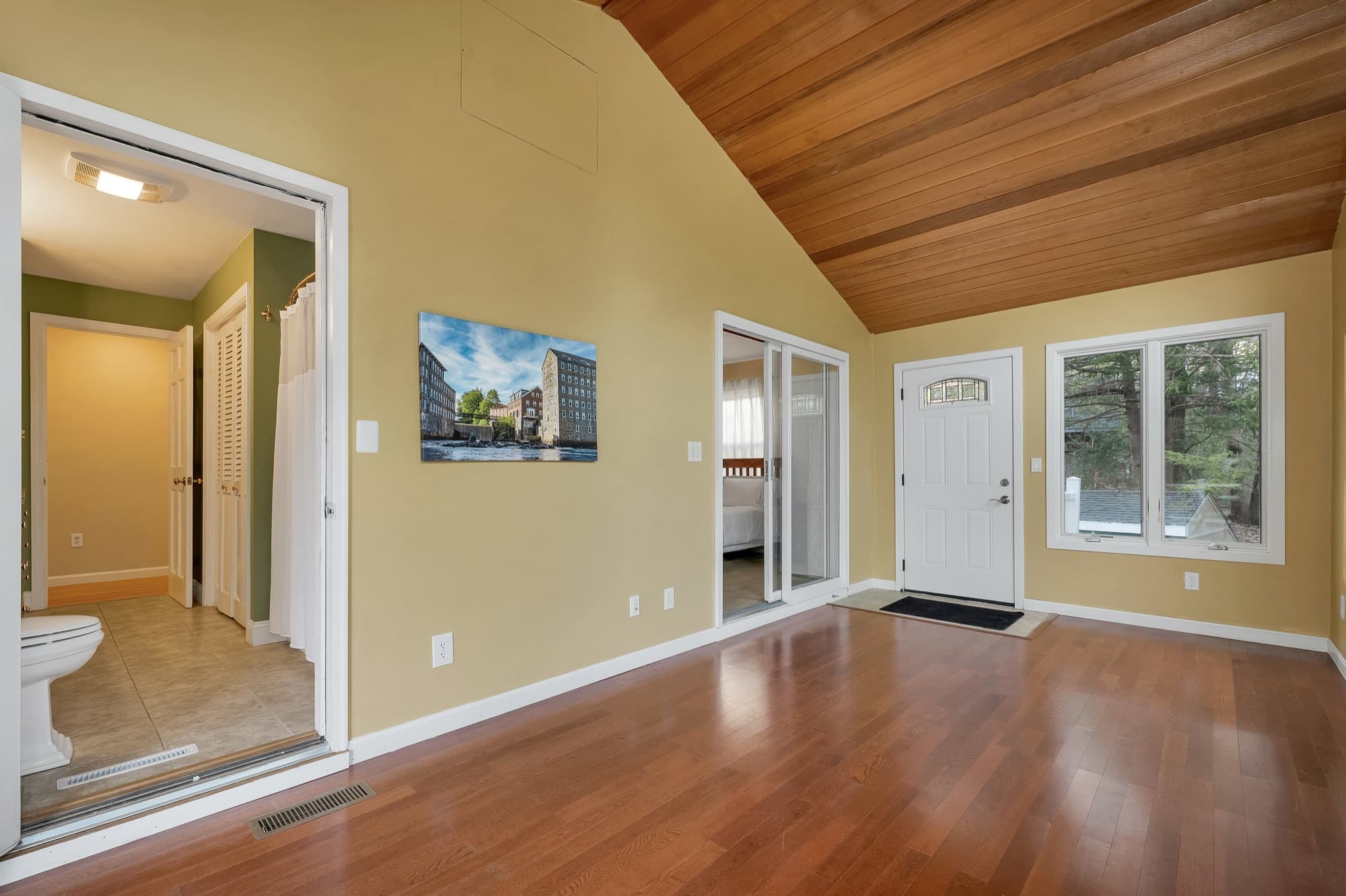 The screened porch from the other end, with hardwood floors and the wood cathedral ceiling