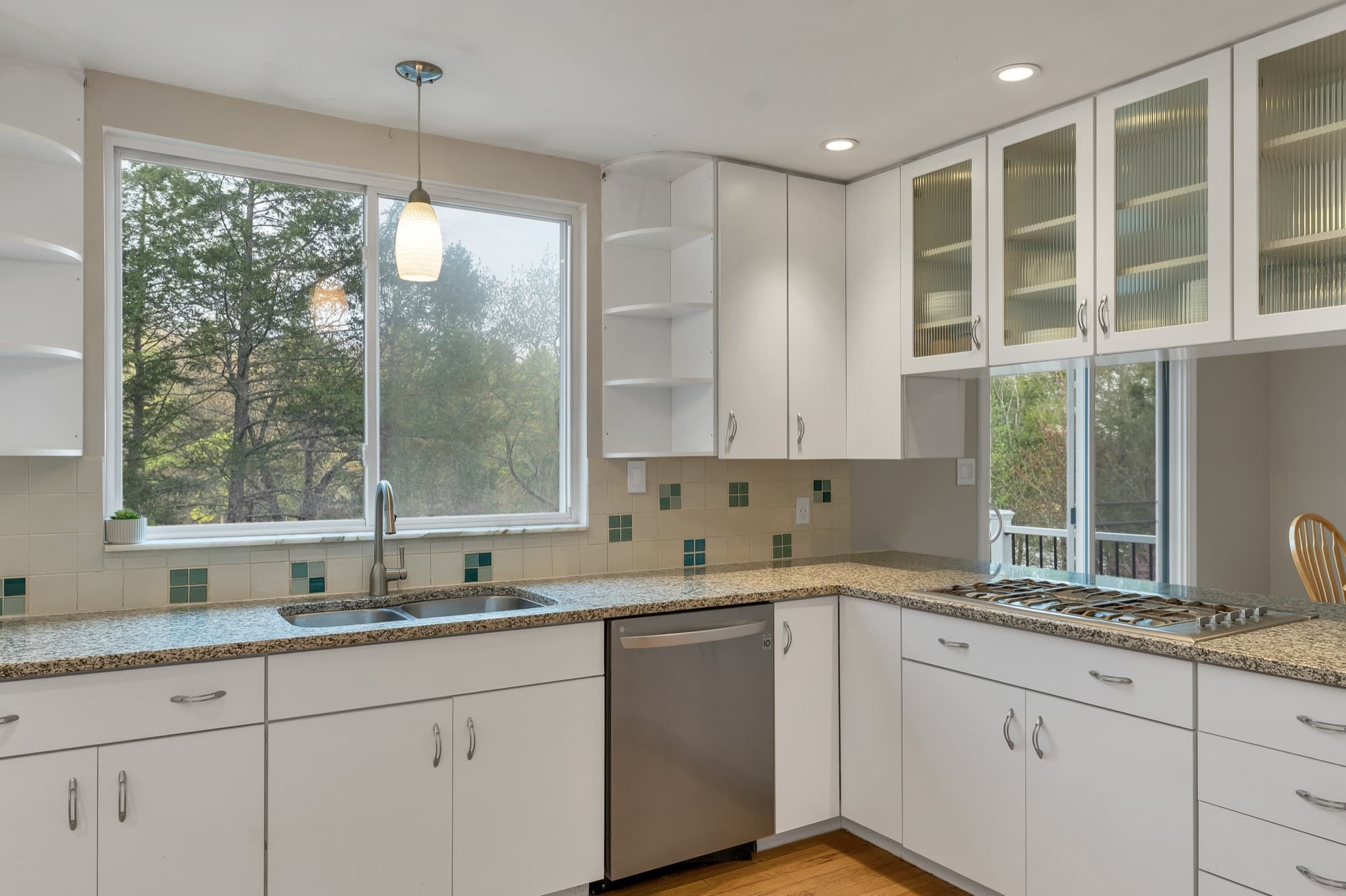 Kitchen with white cabinets, granite counters, a gas cooktop, and a tiled backsplash