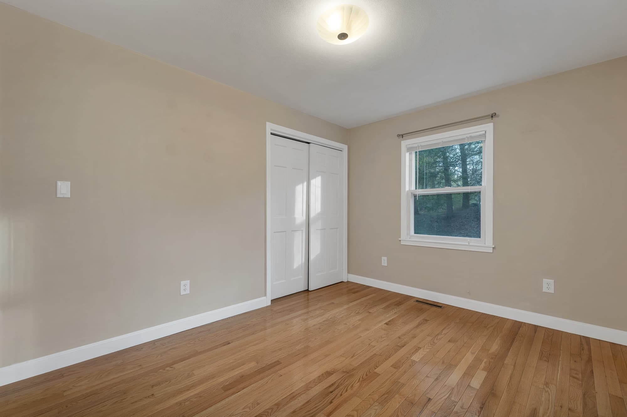Bedroom with hardwood floors and a double closet