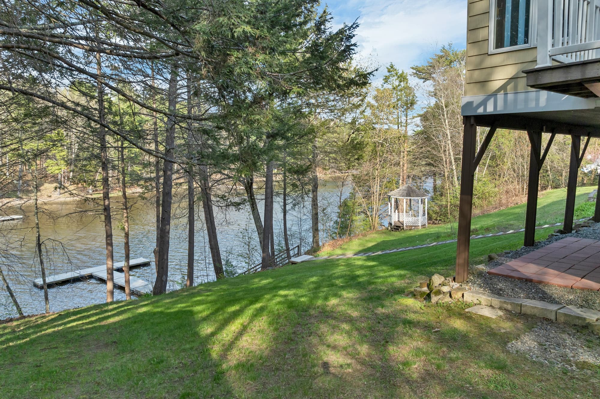 Lawn sloping down through the pines to the river, with the gazebo and dock
