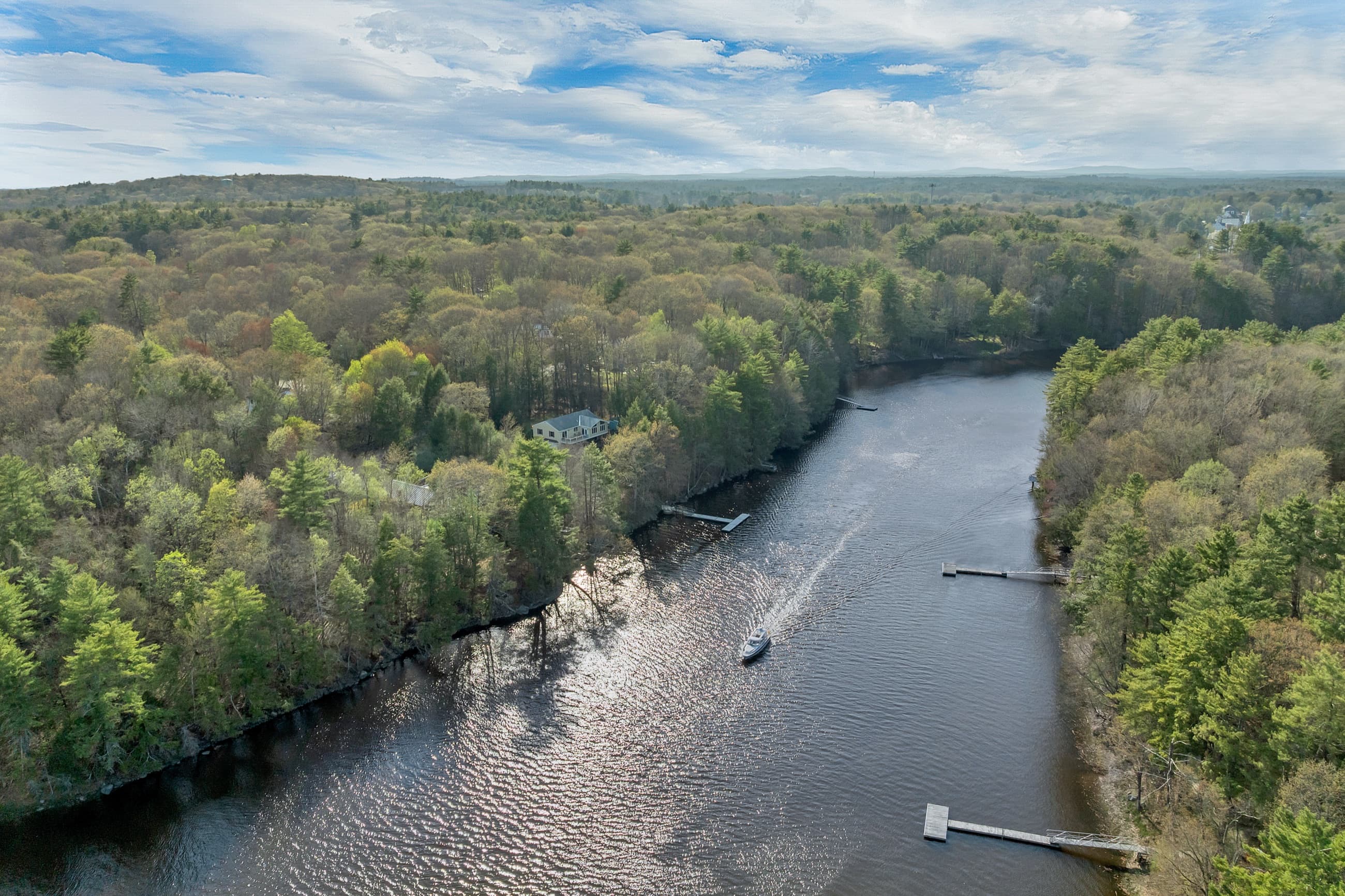 Aerial view along the Lamprey River with a boat underway and the property on the near bank